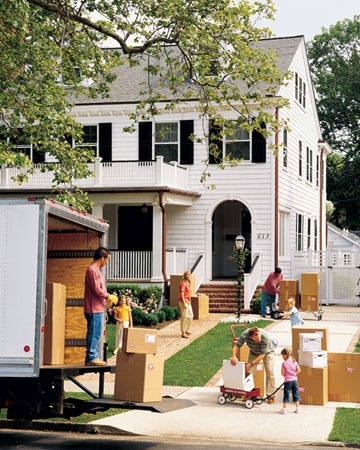 people moving boxes in front of a house