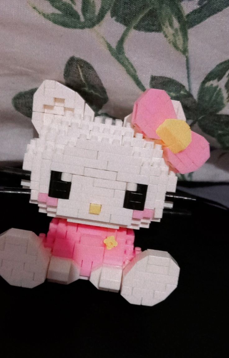 a hello kitty made out of legos sitting on top of a black tablecloth