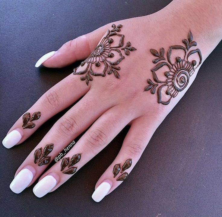 a woman's hand with henna tattoos on it