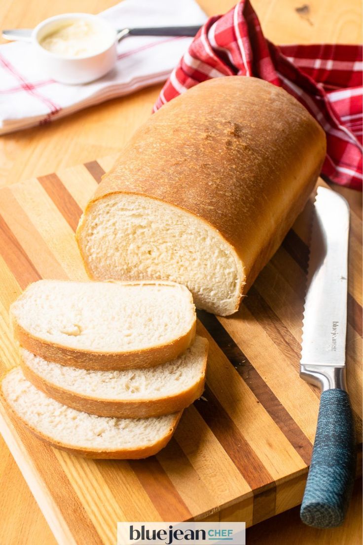 a loaf of bread sitting on top of a wooden cutting board next to a knife