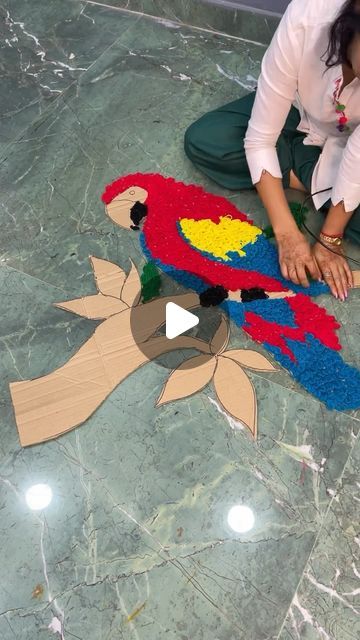 a woman sitting on the floor making a bird decoration