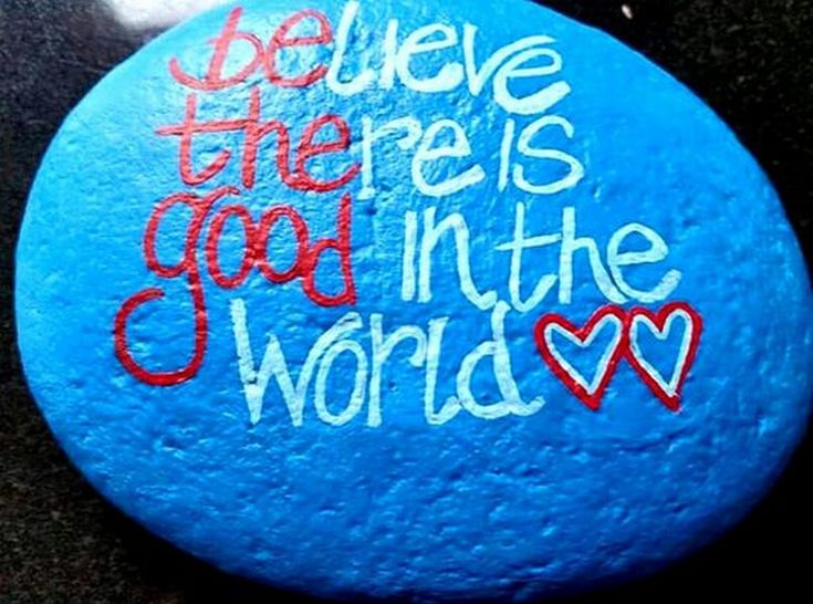 a painted rock with the words believe there is god in the world on it