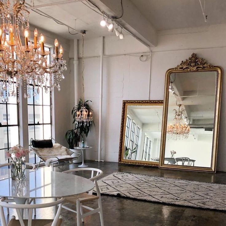 a dining room table and chairs in front of a large mirror