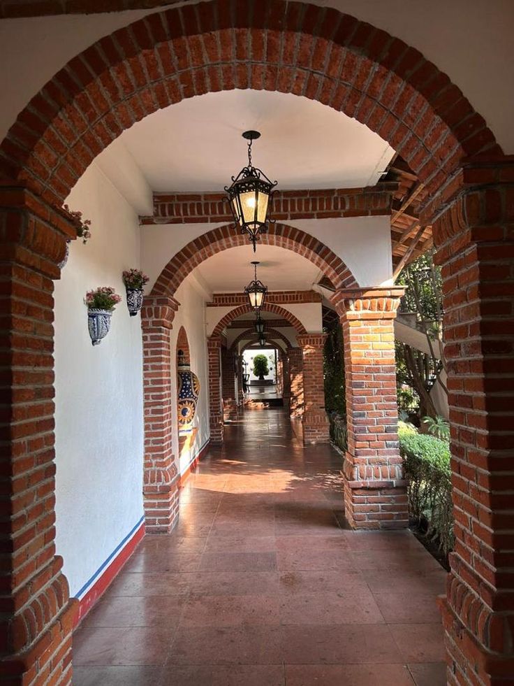 an archway between two buildings with lights hanging from them