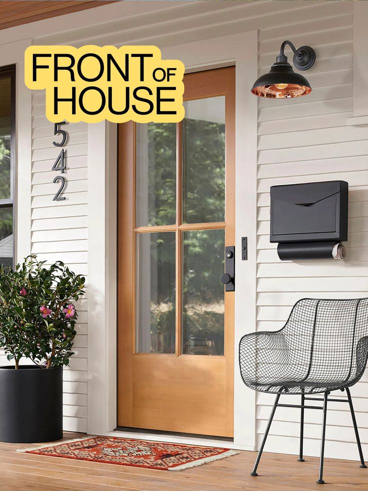 the front door of a house with a chair and potted plant next to it