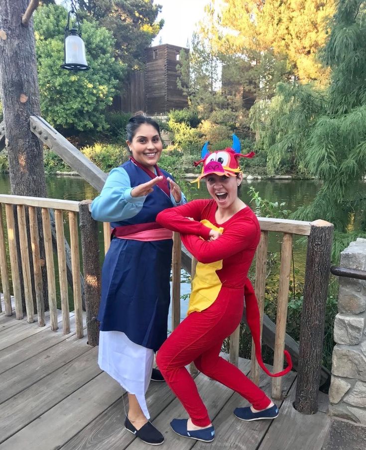 two women in costumes posing on a deck