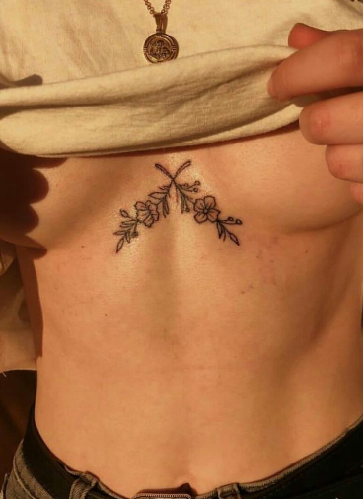 a woman with a cross tattoo on her stomach is shown from the waist to the chest