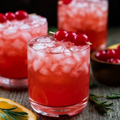 two glasses filled with cranberry lemonade and garnished with fresh rosemary