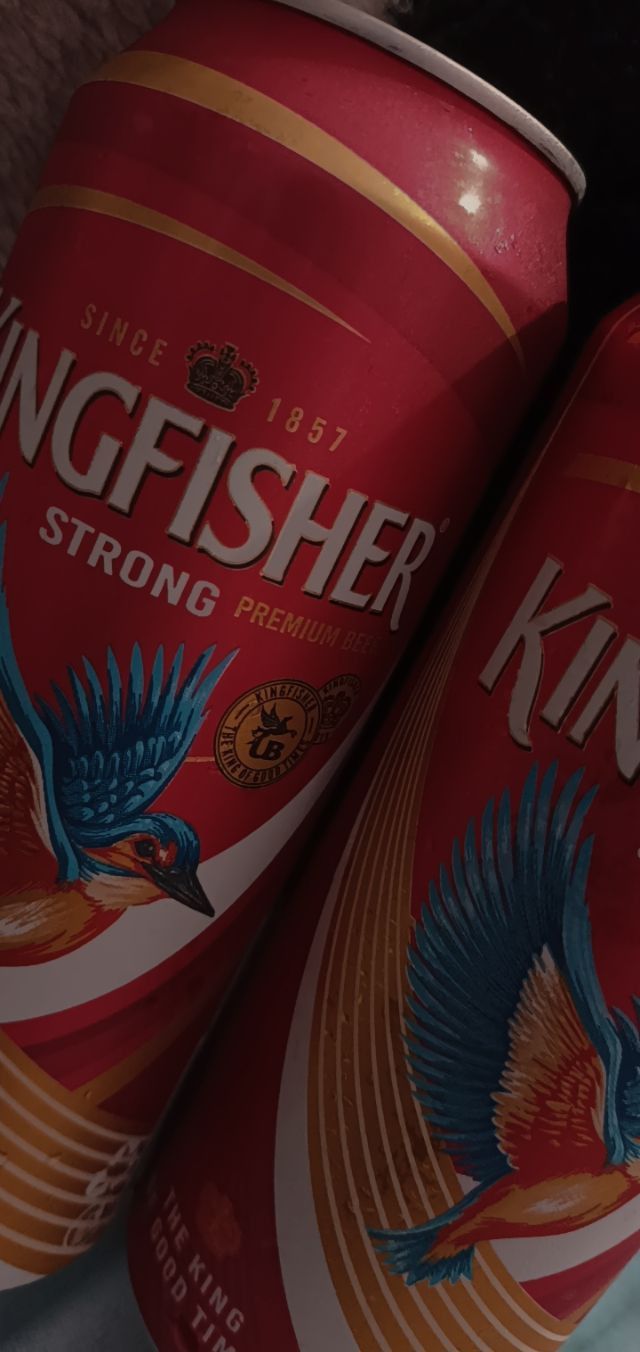 two cans of kingfisher beer sitting next to each other