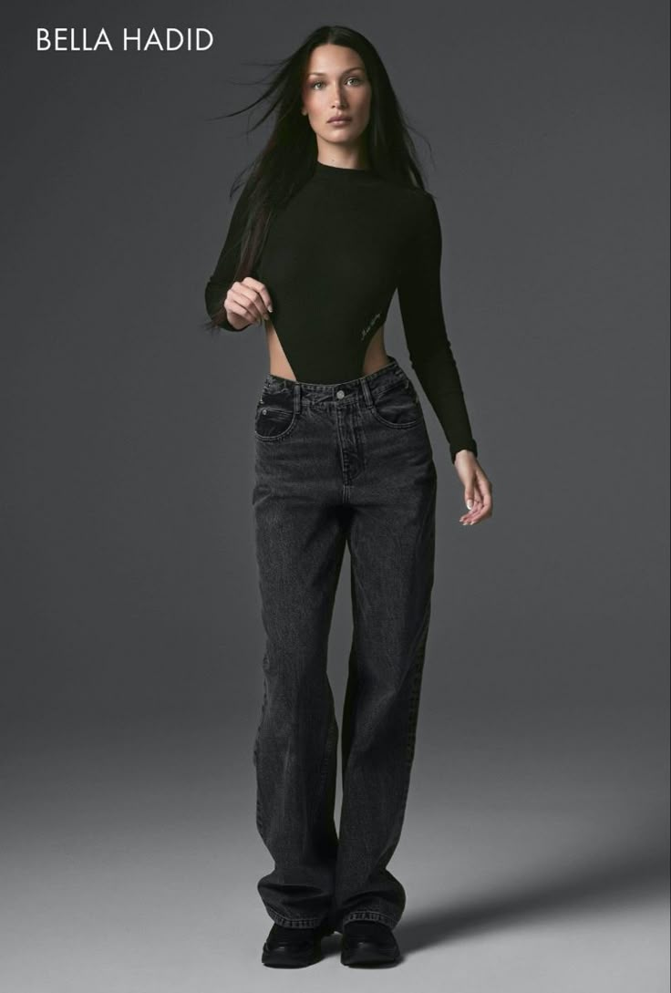 a woman in black shirt and jeans posing for a magazine cover with her hands on her hips