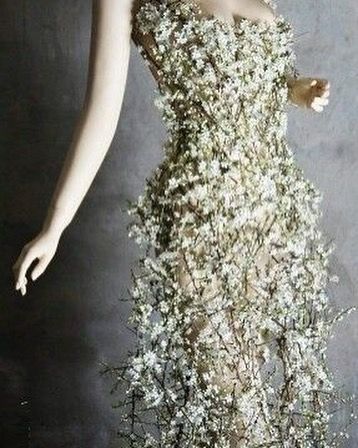 a mannequin is dressed in a dress made out of white flowers and leaves