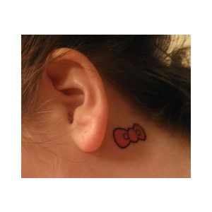 a woman with a small tattoo on her left side behind the ear that says hello kitty