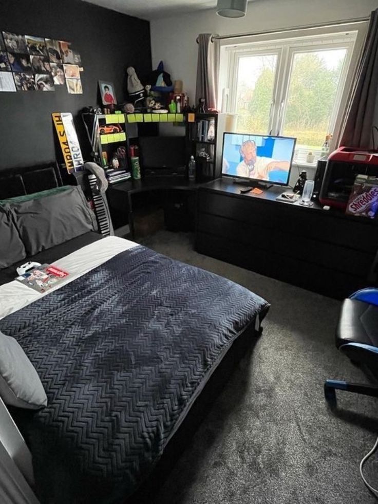 a bed room with a neatly made bed next to a window and a television set