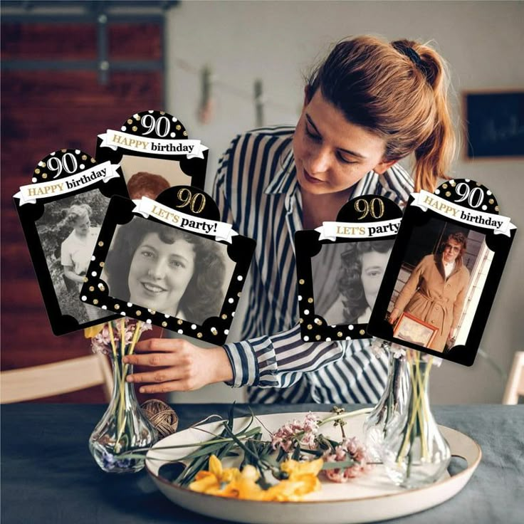 a woman sitting at a table with flowers in front of her and photos on the plate