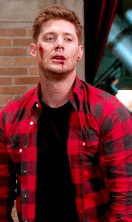 a man in a red and black flannel shirt is making a funny face