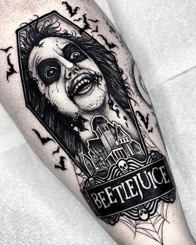 a black and white tattoo with a creepy face