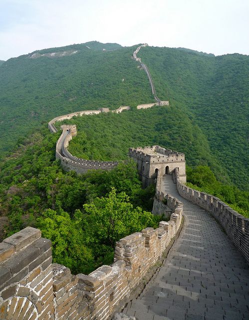 the great wall of china is surrounded by green mountains