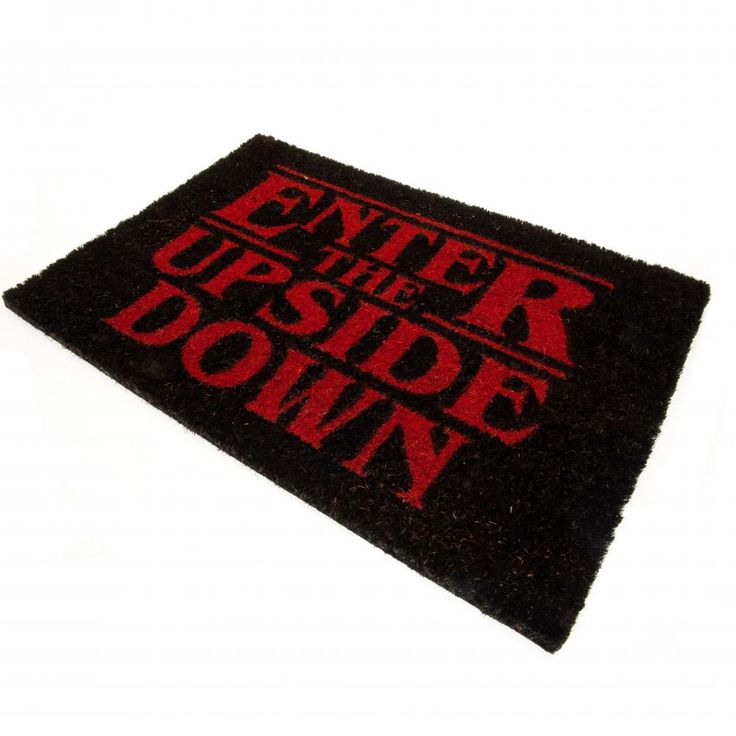 a black and red door mat with the words enter the upside down in red on it