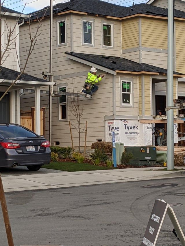 a man on a skateboard in the air doing a trick over a street sign