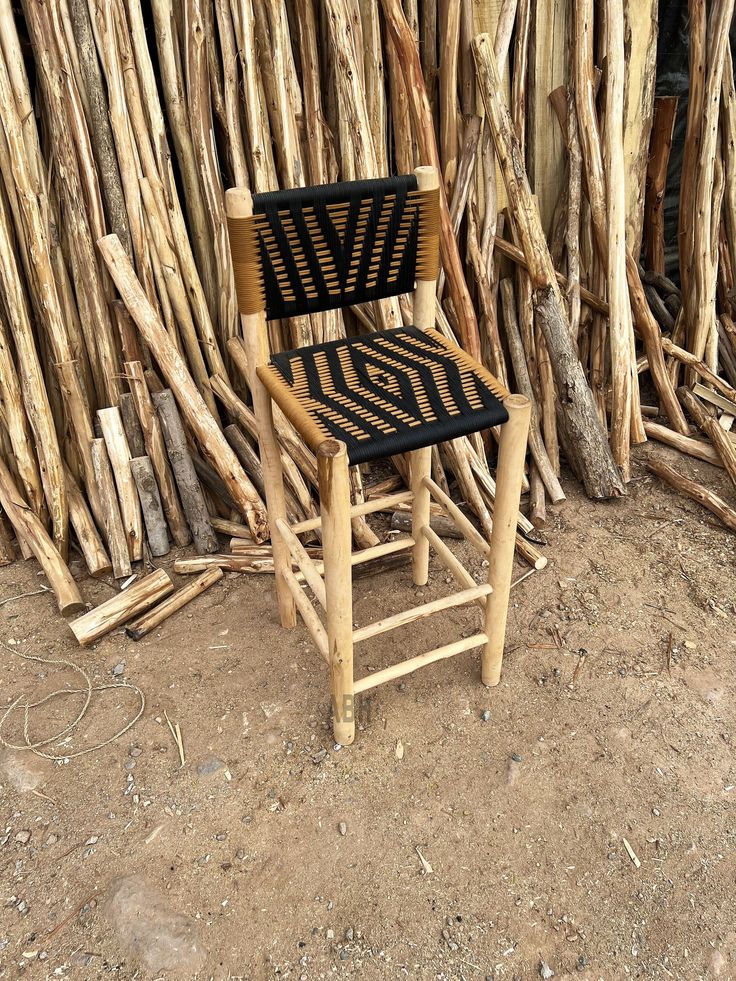 a chair sitting in front of a pile of sticks