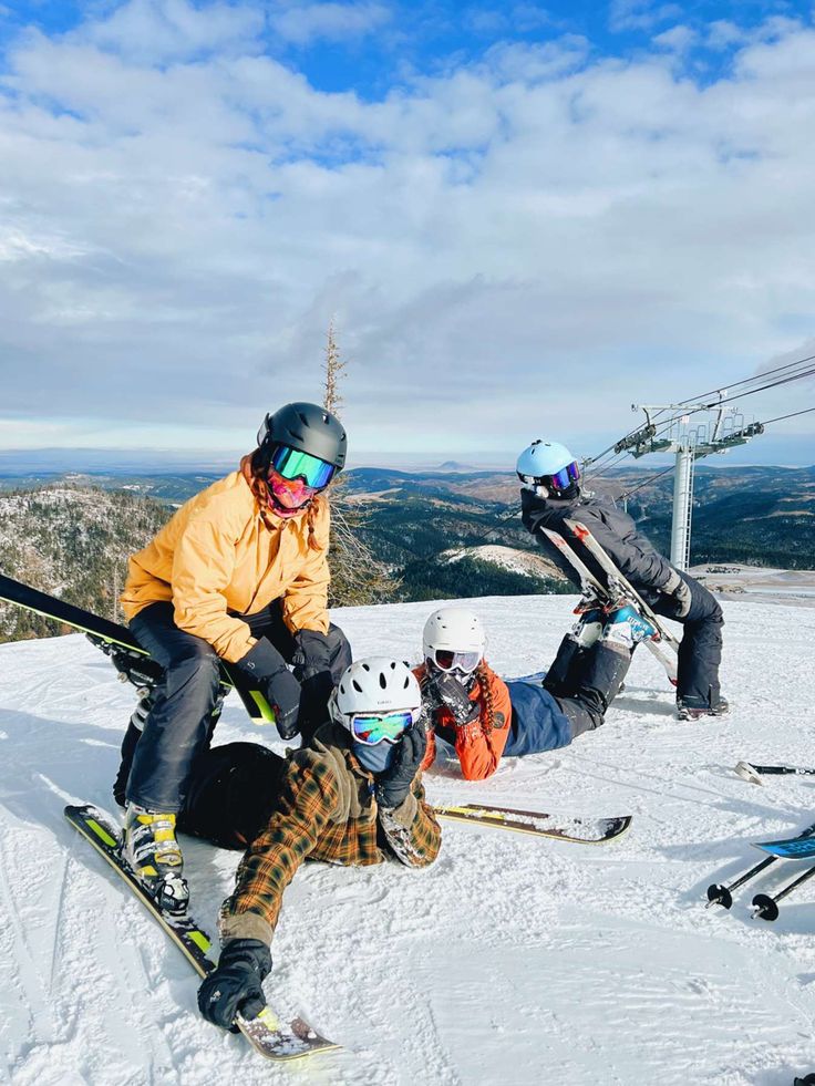 three people on skis in the snow with one person falling off their skis