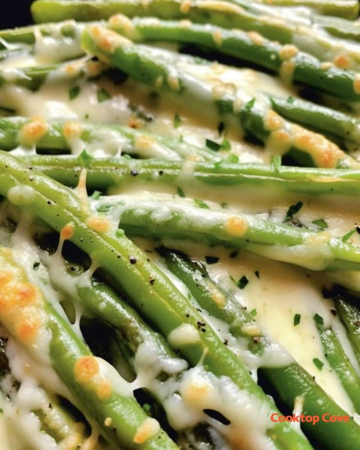 asparagus covered in cheese and sauce on a plate