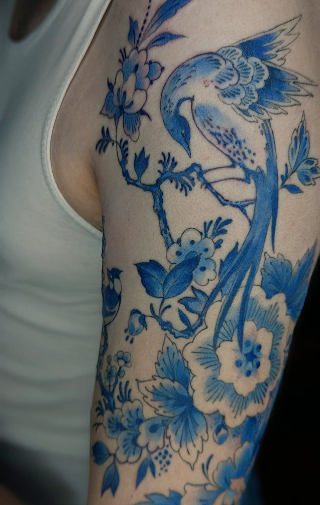 a woman with a blue bird tattoo on her arm