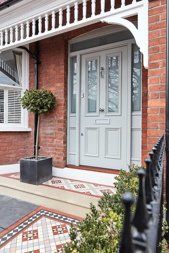 the front door of a brick house with potted plants