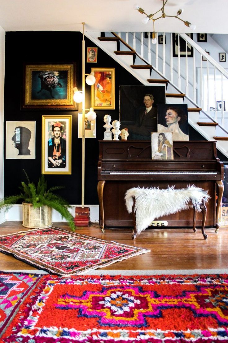 a living room filled with furniture and pictures on the wall next to a stair case