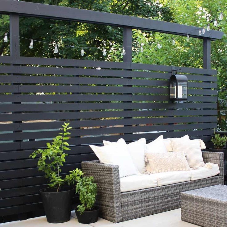 an outdoor seating area with wicker furniture and potted plants