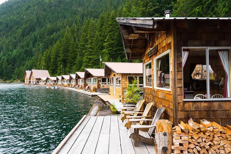 a wooden dock next to a lake with cabins on it