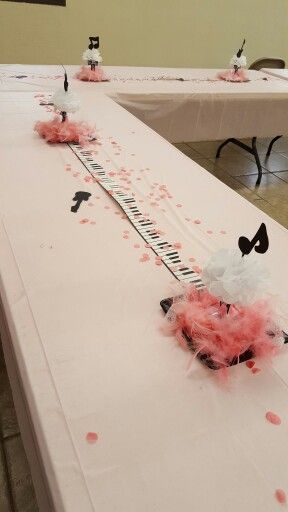 a long table with pink and white decorations on it, along with other tables in the background