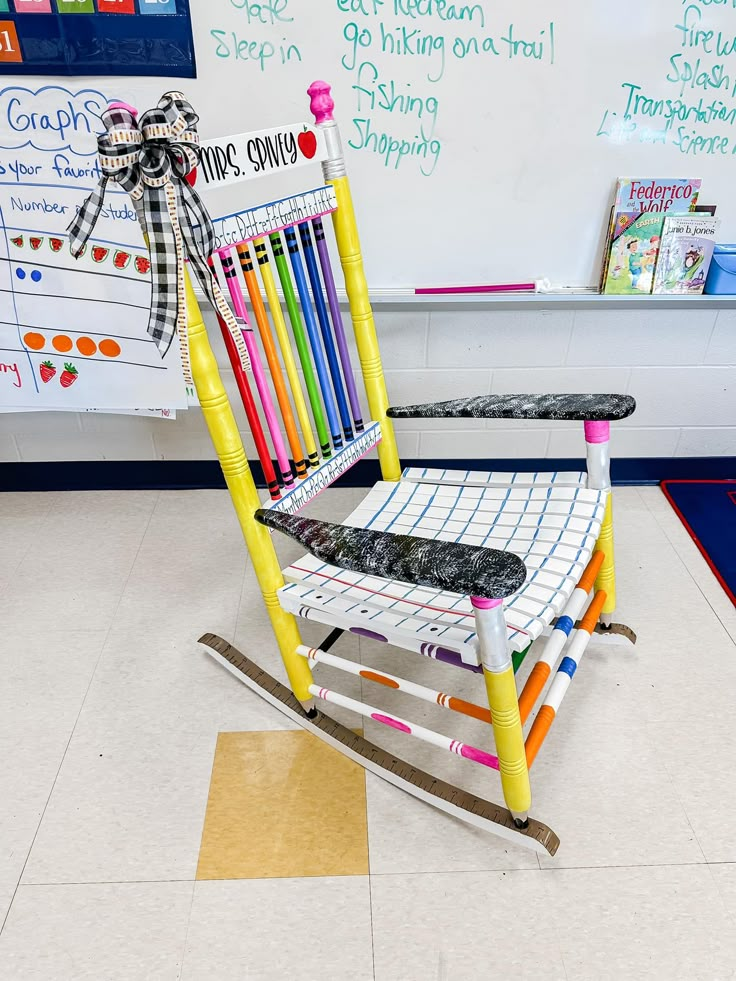 a rocking chair made out of crayons in front of a whiteboard with writing on it