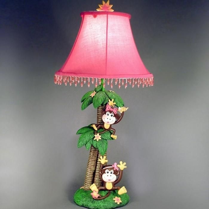 a lamp that is sitting on top of a palm tree with two monkeys in it