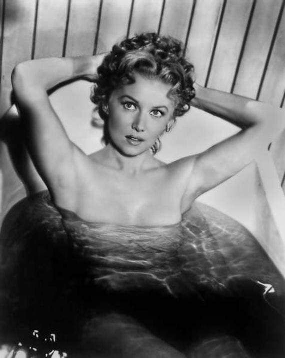 a black and white photo of a woman in a tub