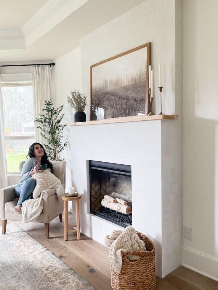 a woman sitting in a chair next to a fire place