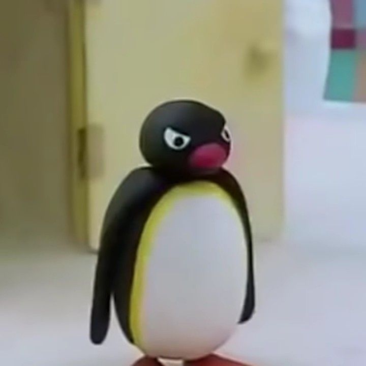 a small toy penguin standing on top of a table