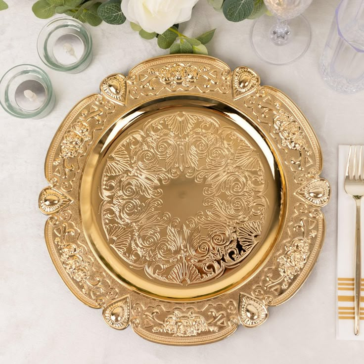 a gold plate and silverware on a table