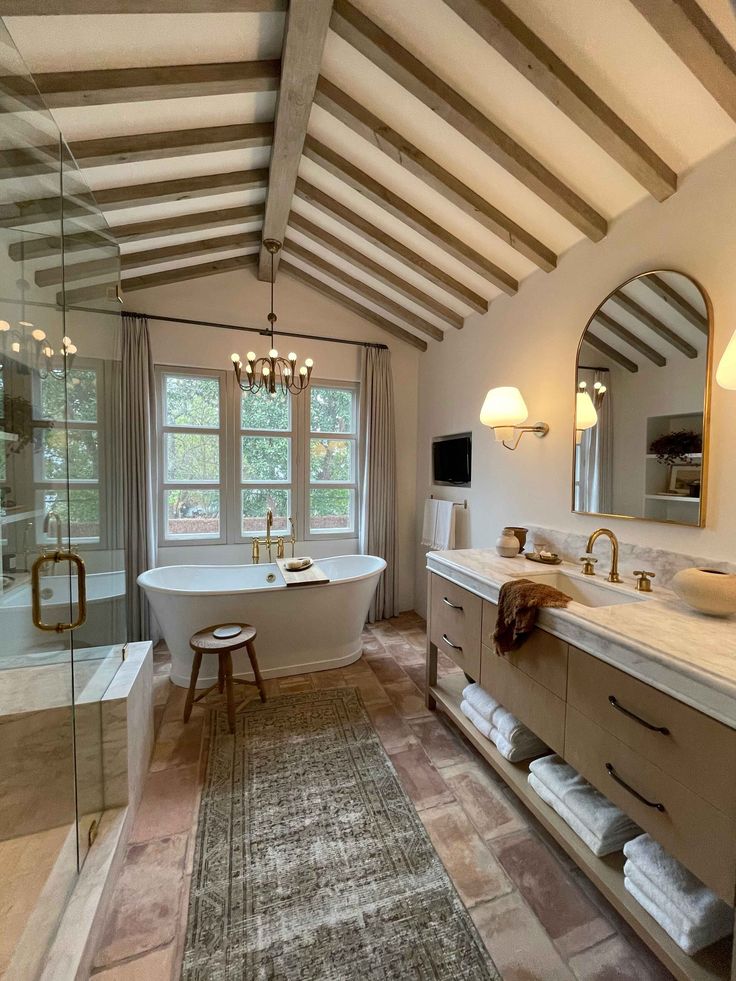 a bath room with a tub a sink and a large mirror on the wall above it