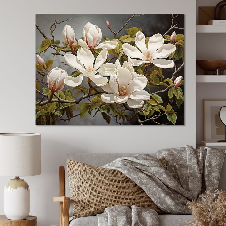 white flowers on a tree branch in front of a wall mounted art piece by the bed