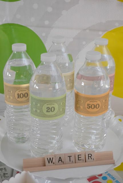 three bottled water bottles sitting on top of a white plate next to a scrabble