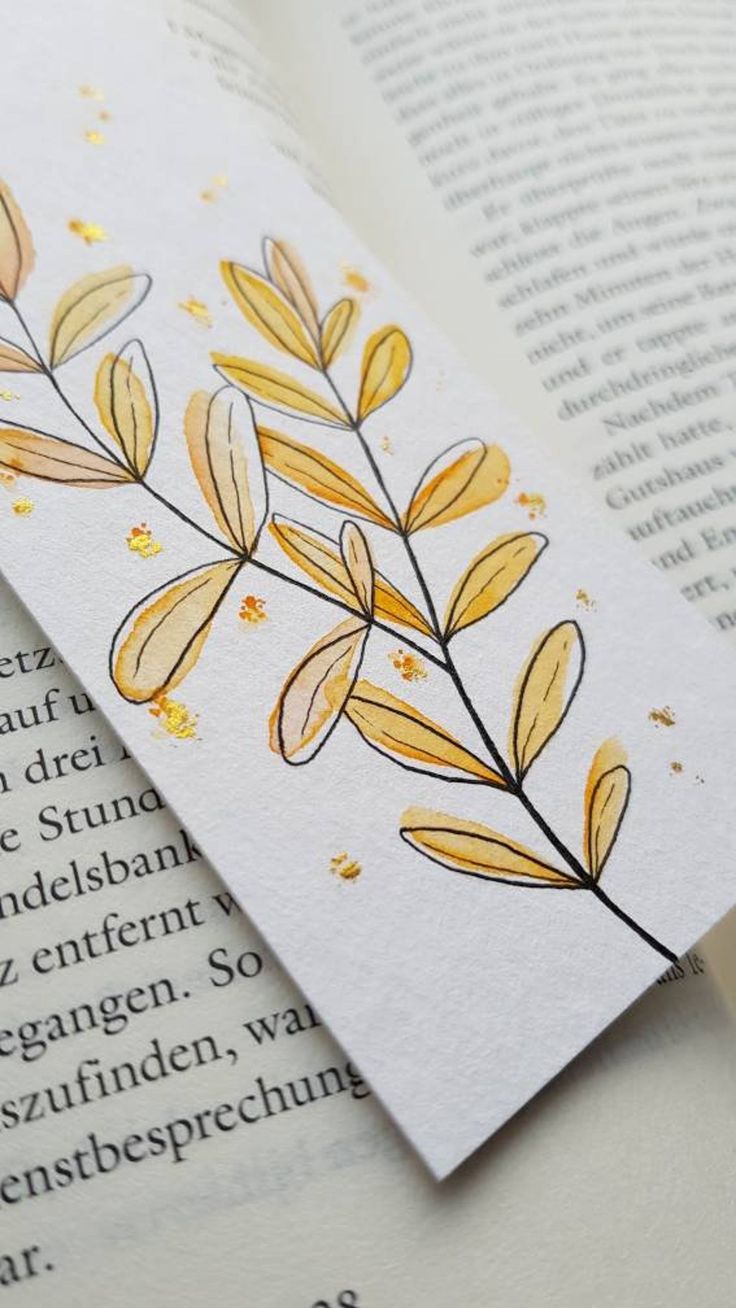 an open book with some yellow leaves on it