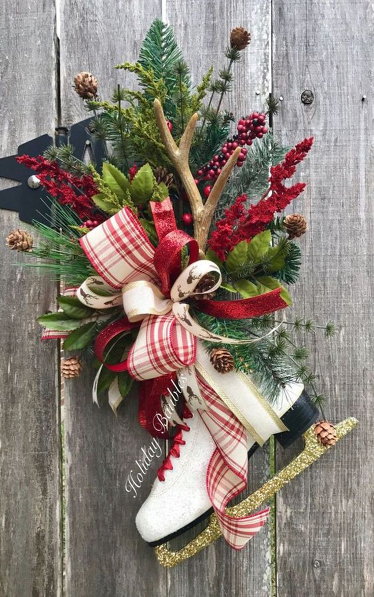 a christmas wreath hanging on the side of a wooden fence with skis and greenery