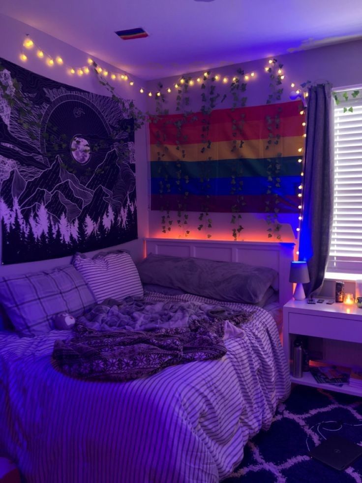 a bedroom with purple lights and a rainbow wall hanging above the bed, along with a rug on the floor