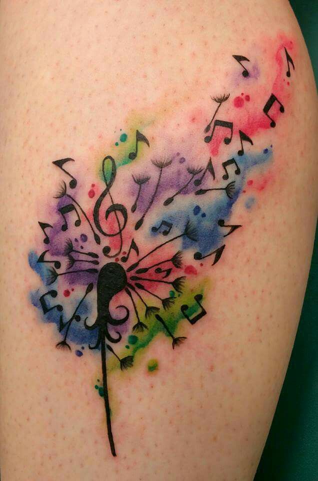 a watercolor tattoo with music notes and a dandelion on the back of a woman's thigh