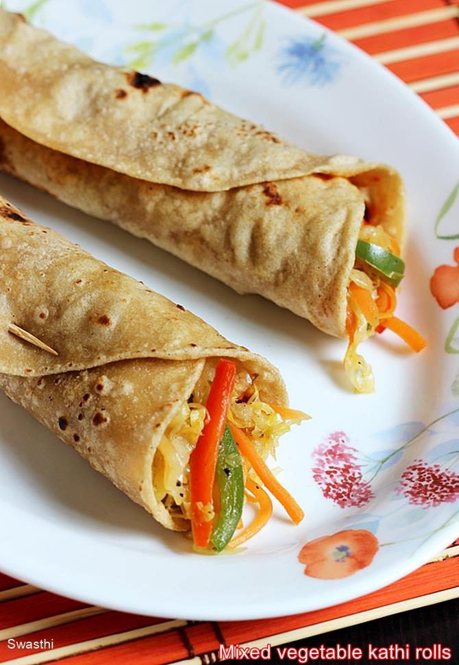 two burritos are sitting on a plate with carrots and peppers in them