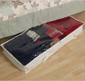 an open suitcase on the floor next to a bed with red and blue blankets in it