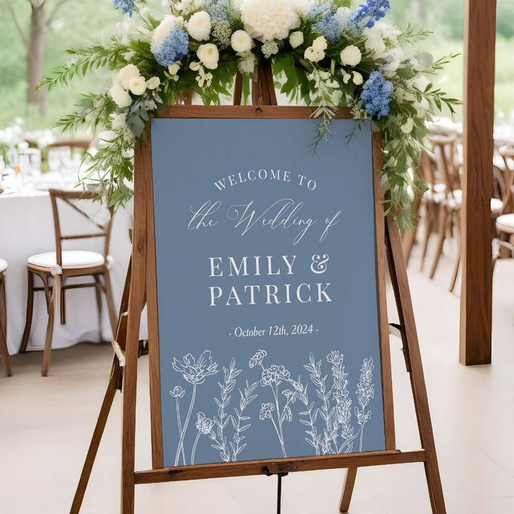 a welcome sign with flowers and greenery is displayed in front of the reception tables