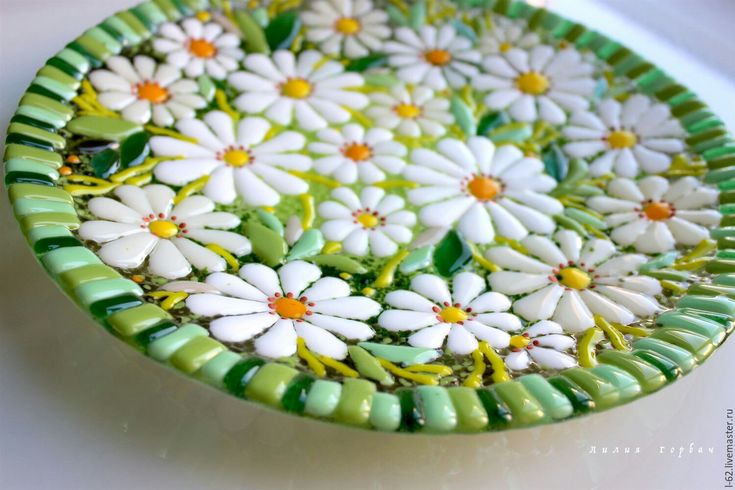 a green and white plate with flowers on it