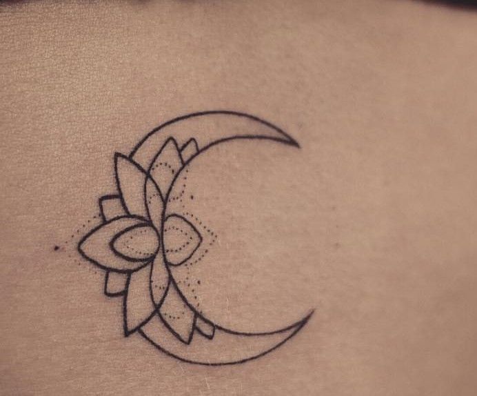 a woman's stomach with a crescent tattoo on her belly and a flower in the middle